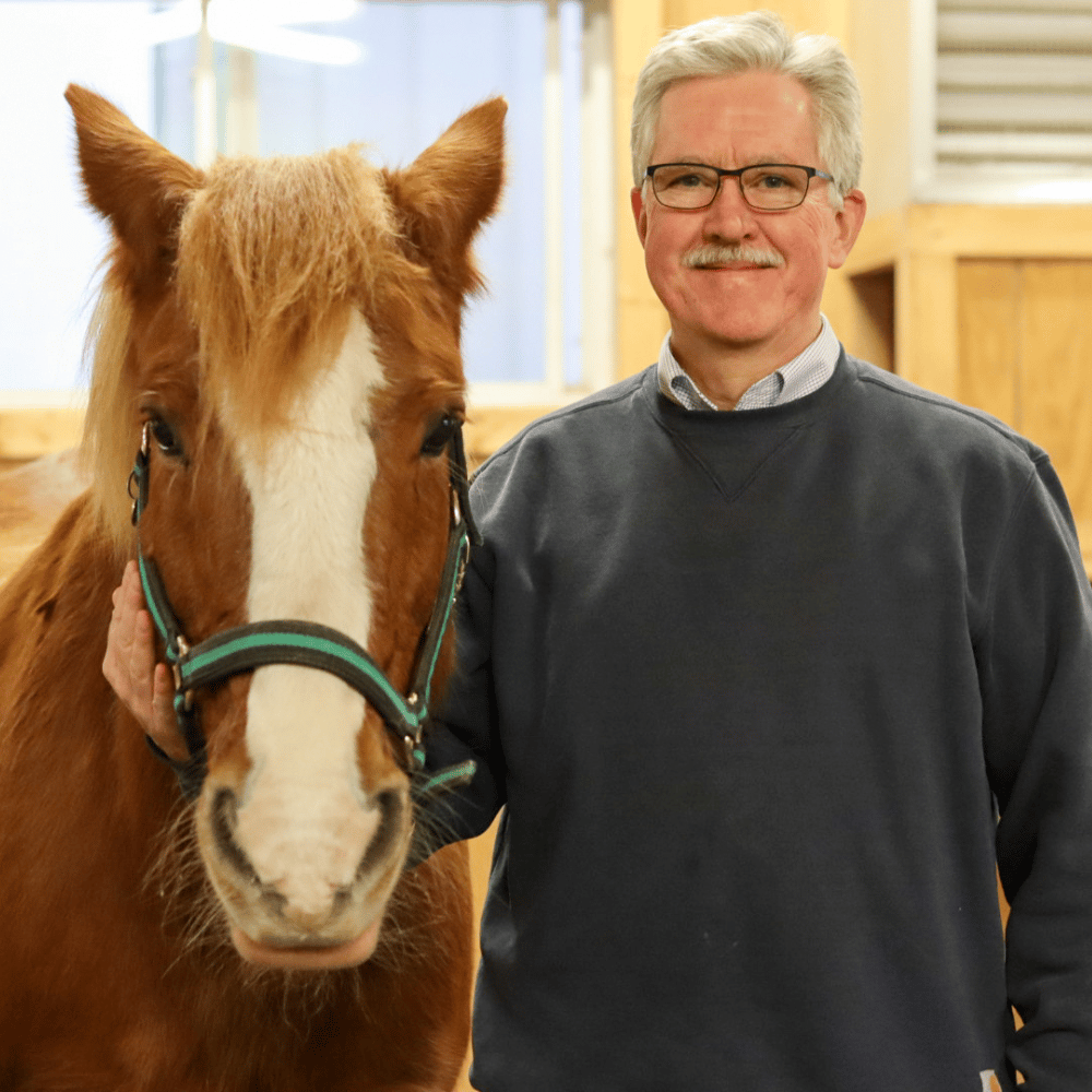 Tom Gaughan, the newest member of Main Stay's Board of Directors smiles with adaptive riding horse, Harry